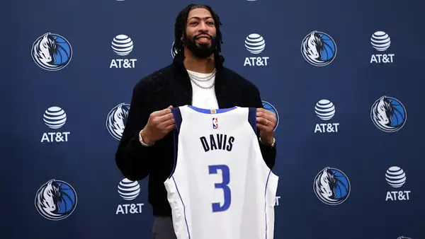 An image of Anthony Davis holding his mavericks jersey.