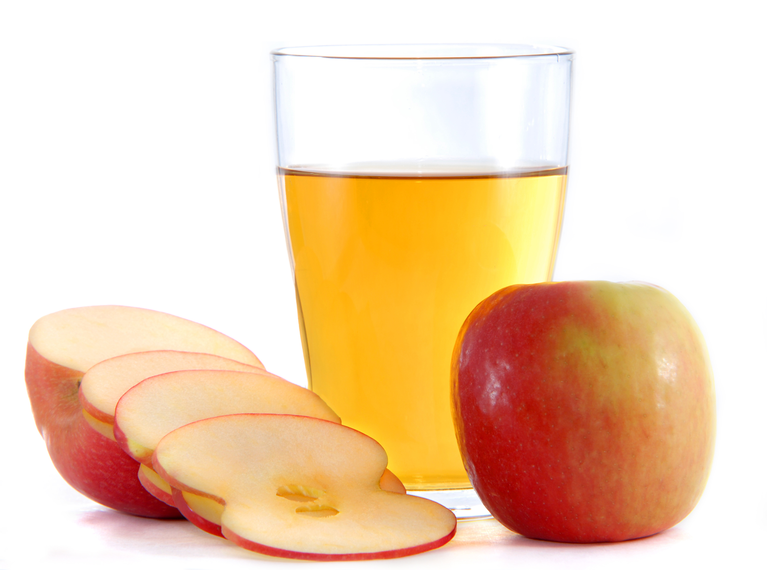 A fresh cup of apple juice on a table with apples