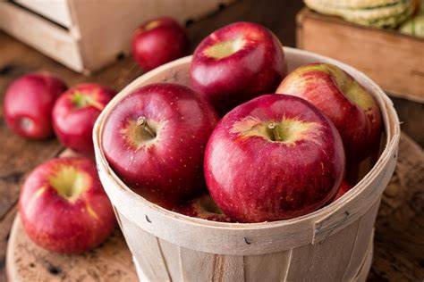 red apples in a basket, with more red apples in the background